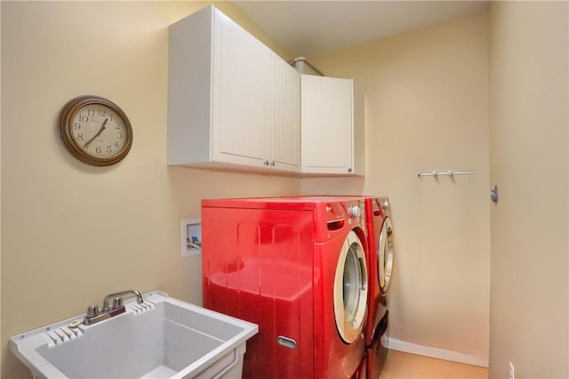 clothes washing area with cabinets, washer and clothes dryer, and sink