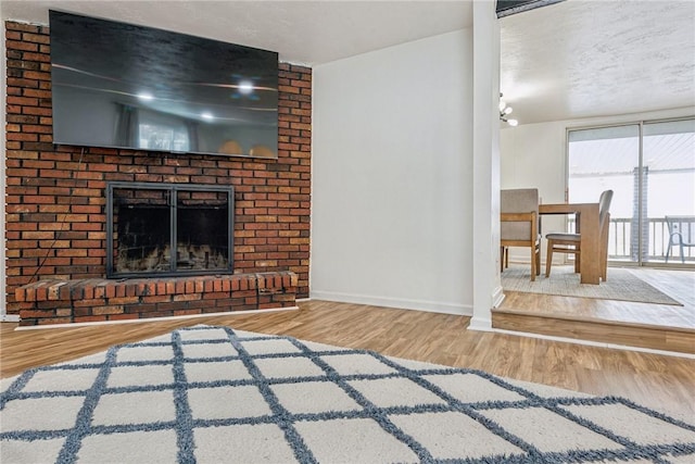 unfurnished living room with a fireplace, a textured ceiling, and wood-type flooring