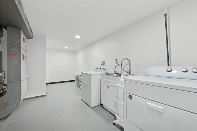 laundry room with cabinets, washer and clothes dryer, and sink