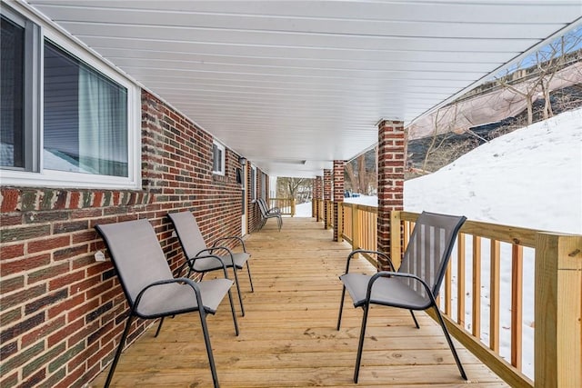 snow covered deck with a porch