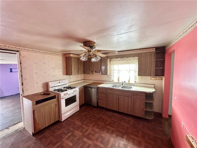 kitchen with sink, dark parquet floors, ceiling fan, stainless steel dishwasher, and gas range gas stove