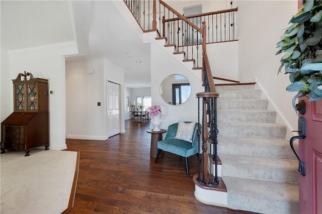 stairway with ornamental molding and hardwood / wood-style floors