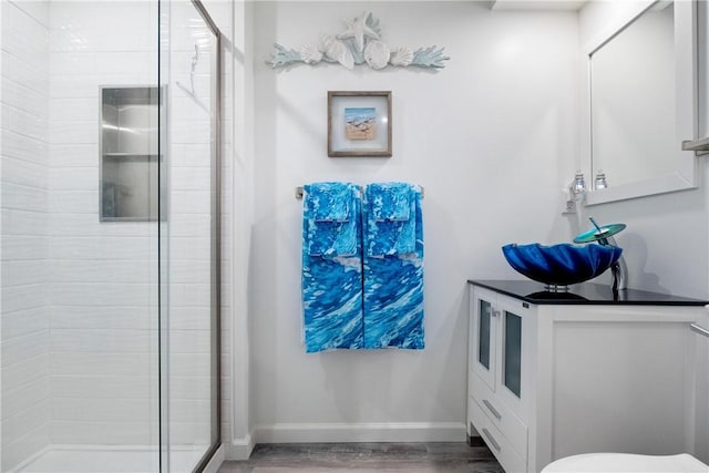 bathroom with hardwood / wood-style flooring and a shower with door