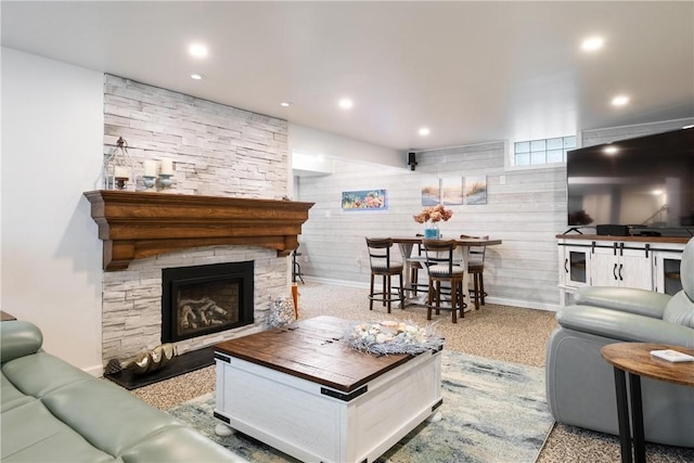 living room featuring wooden walls and a fireplace