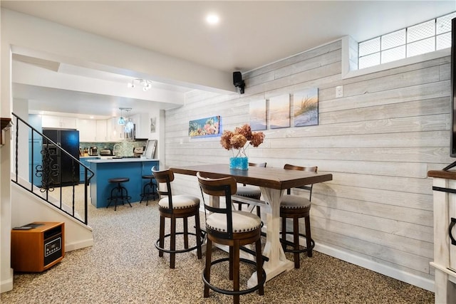 dining room featuring wood walls