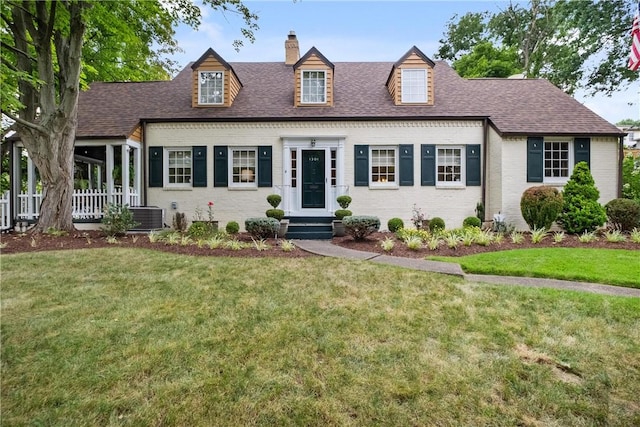 cape cod house with a front yard and cooling unit