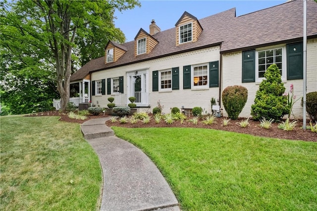 cape cod house with a front lawn