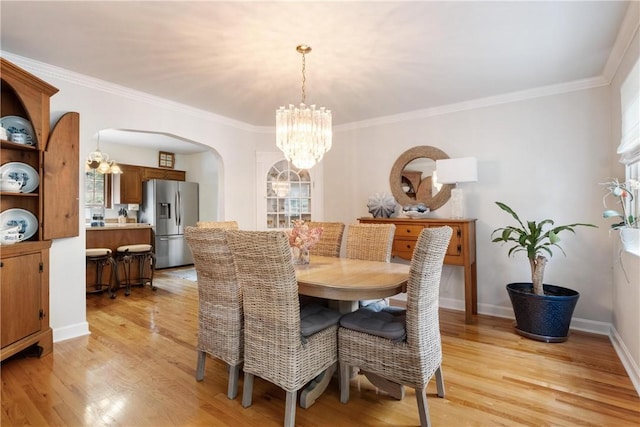 dining room featuring a chandelier, ornamental molding, and light hardwood / wood-style flooring