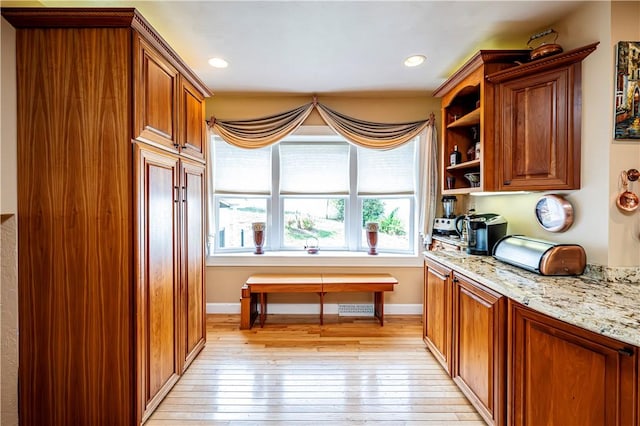 kitchen featuring light stone countertops and light hardwood / wood-style flooring