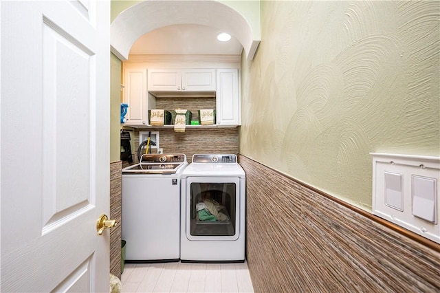 washroom featuring cabinets and washer and clothes dryer