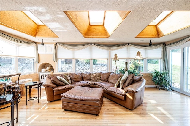 sunroom featuring a raised ceiling and a skylight