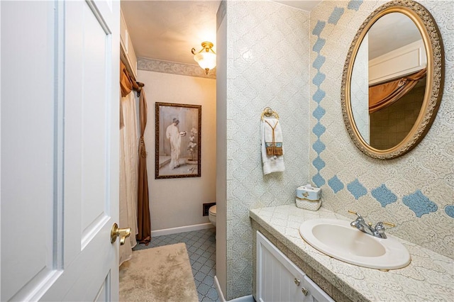 bathroom with toilet, vanity, and tile patterned floors