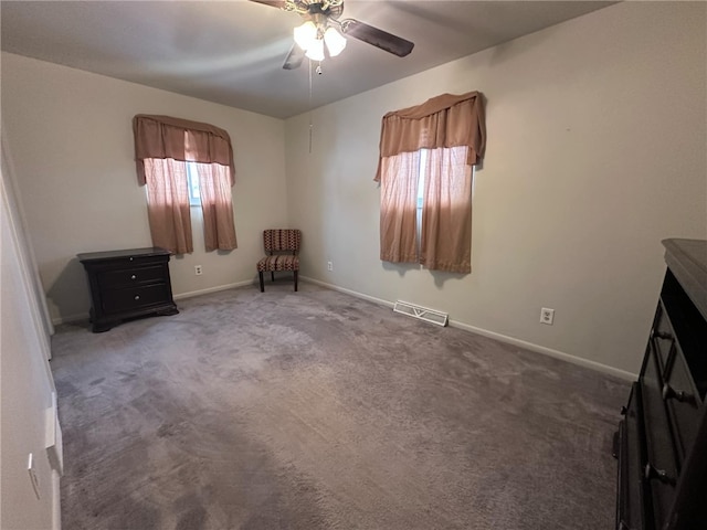 unfurnished bedroom with ceiling fan and dark colored carpet