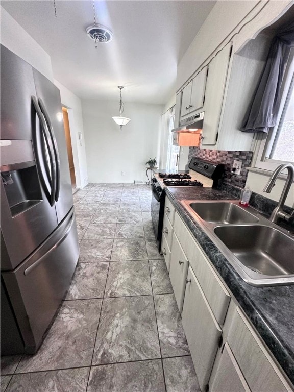 kitchen featuring stainless steel fridge with ice dispenser, black range with gas stovetop, sink, decorative light fixtures, and backsplash