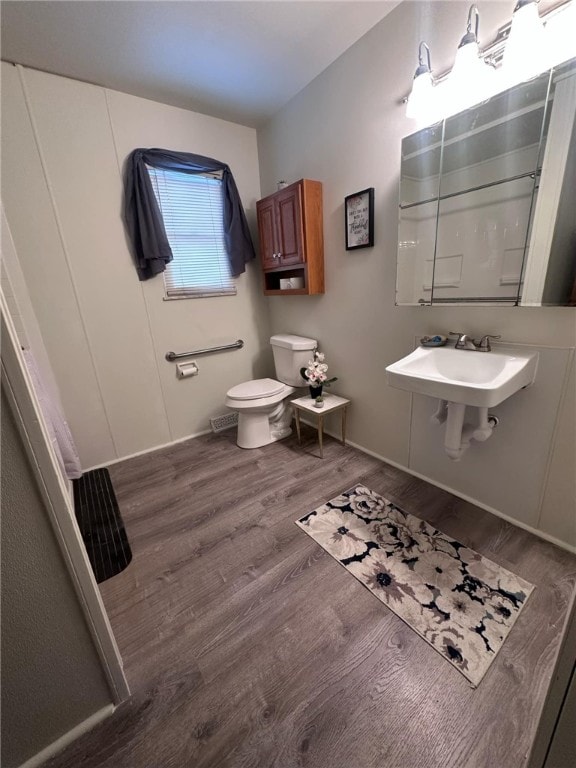 bathroom with sink, toilet, and hardwood / wood-style flooring