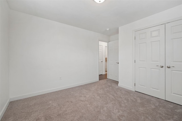 unfurnished bedroom featuring a closet and light carpet