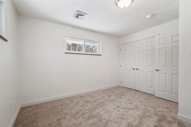 unfurnished bedroom featuring a closet and light carpet