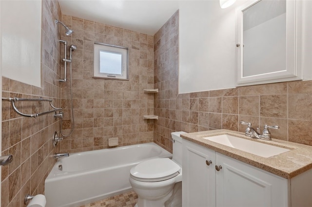 full bathroom featuring tiled shower / bath, tile walls, tasteful backsplash, toilet, and vanity