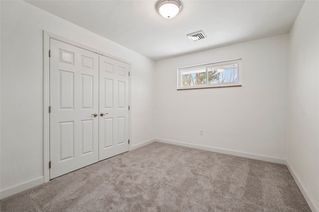 unfurnished bedroom featuring a closet and light carpet