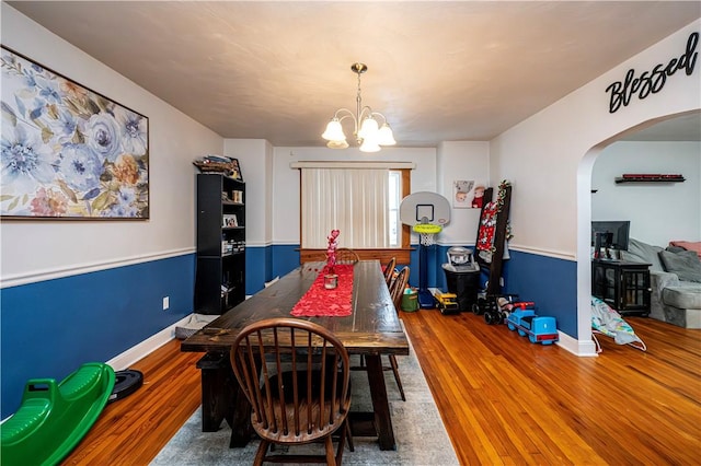 dining room with hardwood / wood-style floors and an inviting chandelier