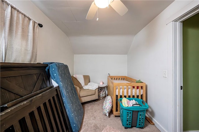 bedroom with lofted ceiling, a nursery area, light carpet, and ceiling fan