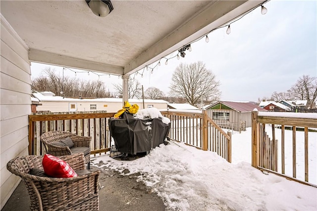 snow covered deck featuring area for grilling