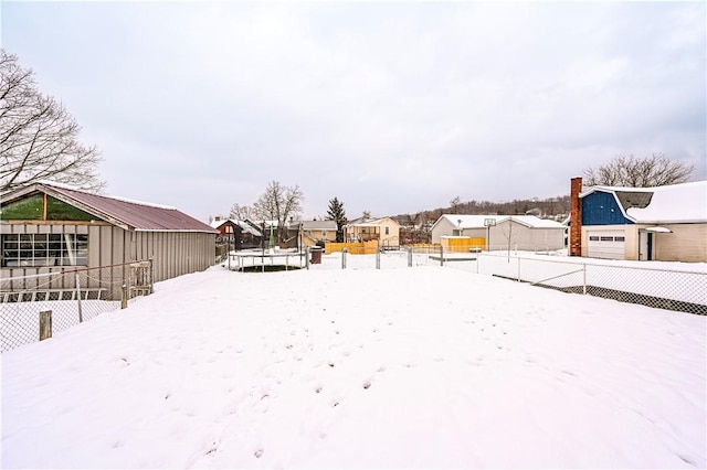 snowy yard featuring a trampoline