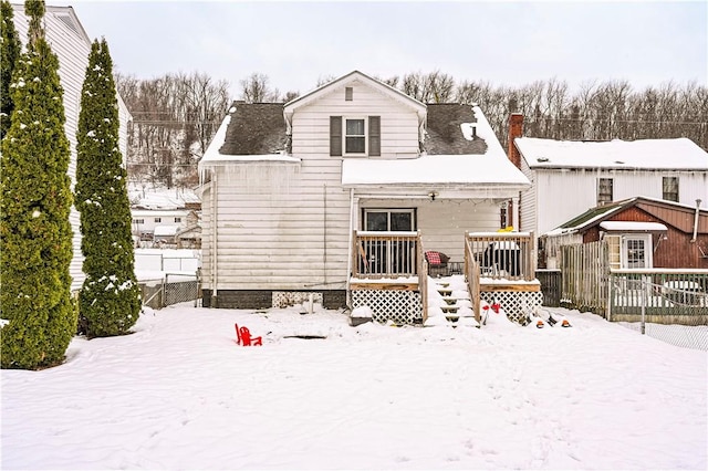 view of snow covered back of property