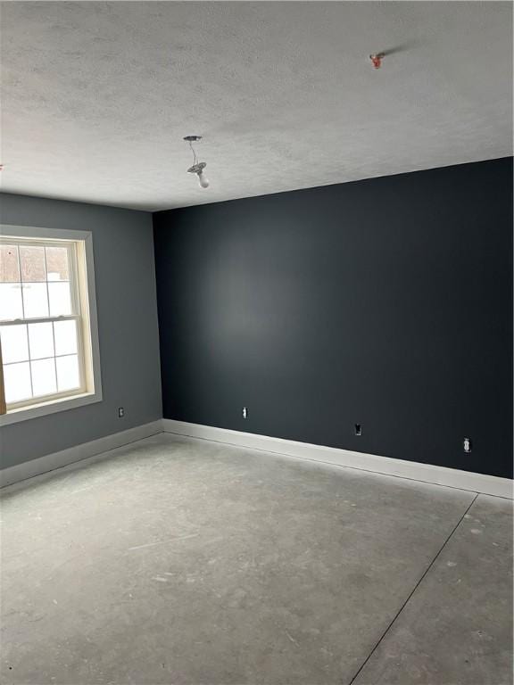 unfurnished room with a textured ceiling