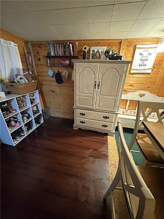 bedroom featuring dark wood-type flooring and wooden walls