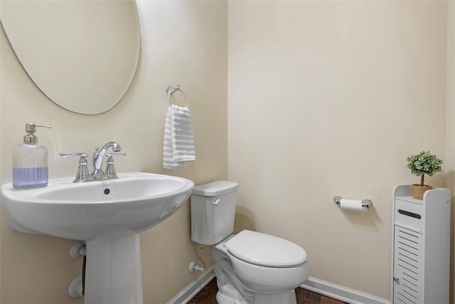 bathroom with toilet and wood-type flooring