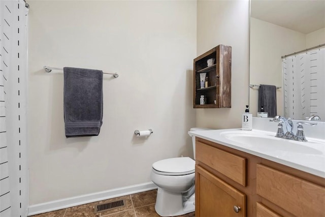 bathroom with toilet, vanity, and curtained shower