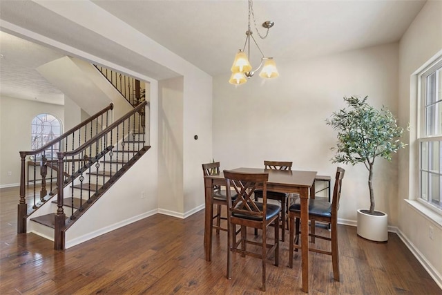 dining space with dark hardwood / wood-style floors and a notable chandelier