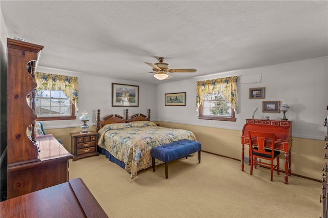 carpeted bedroom with ceiling fan and a textured ceiling