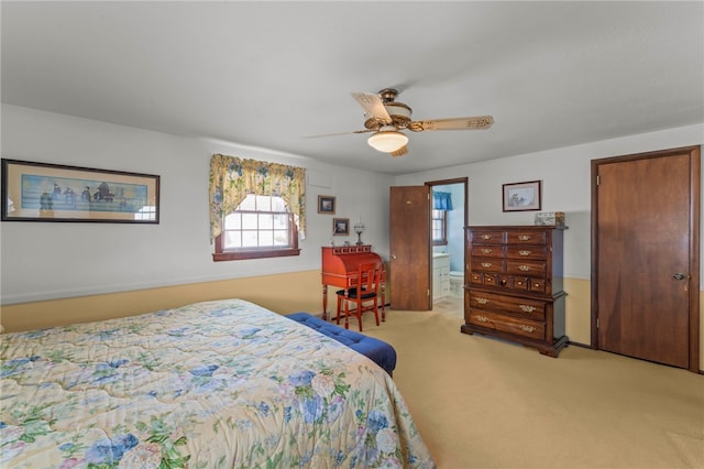 bedroom with ensuite bathroom, ceiling fan, and light colored carpet