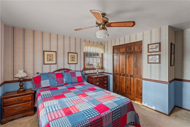 carpeted bedroom featuring ceiling fan and a closet