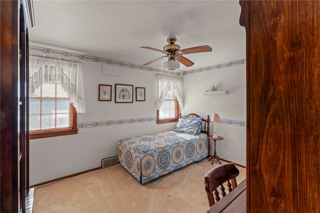 carpeted bedroom featuring ceiling fan and multiple windows