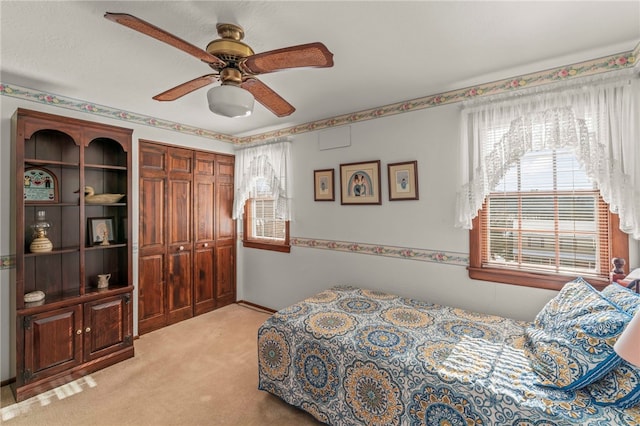 carpeted bedroom featuring a closet and ceiling fan