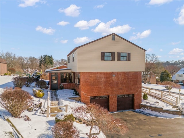 snow covered property with a garage