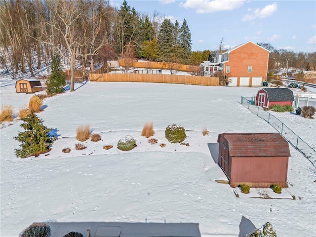 yard covered in snow featuring a shed