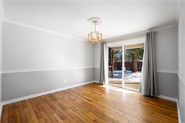 unfurnished room with hardwood / wood-style floors, a chandelier, and ornamental molding