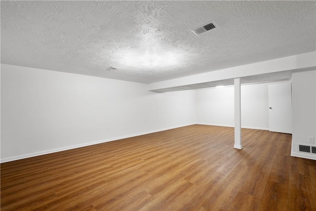 basement with a textured ceiling and hardwood / wood-style flooring