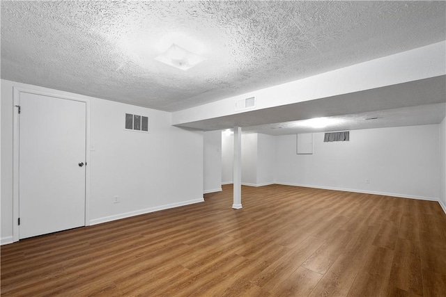 basement featuring hardwood / wood-style flooring and a textured ceiling