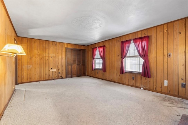 carpeted empty room with wooden walls