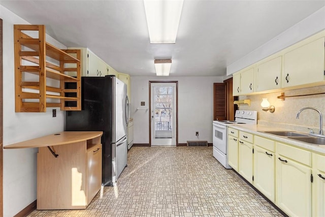 kitchen with sink, backsplash, white range with electric stovetop, and stainless steel refrigerator