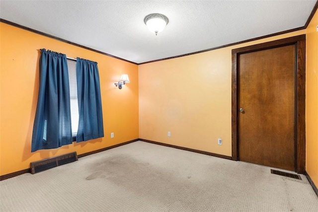 carpeted empty room with crown molding and a textured ceiling