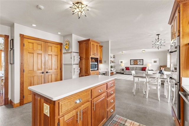 kitchen featuring a kitchen island, decorative light fixtures, an inviting chandelier, and double oven