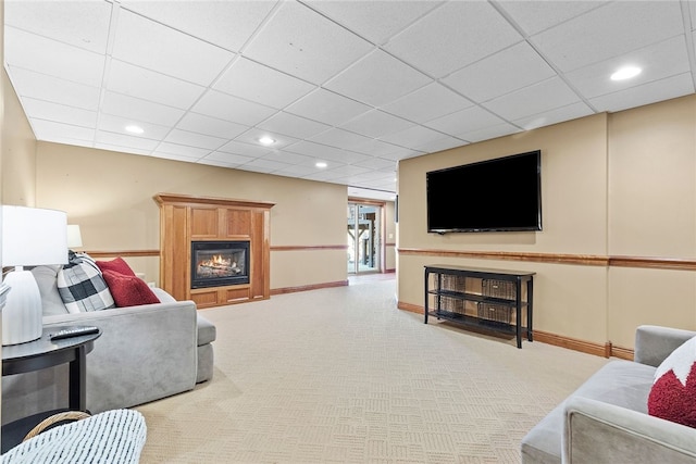 carpeted living room with a drop ceiling