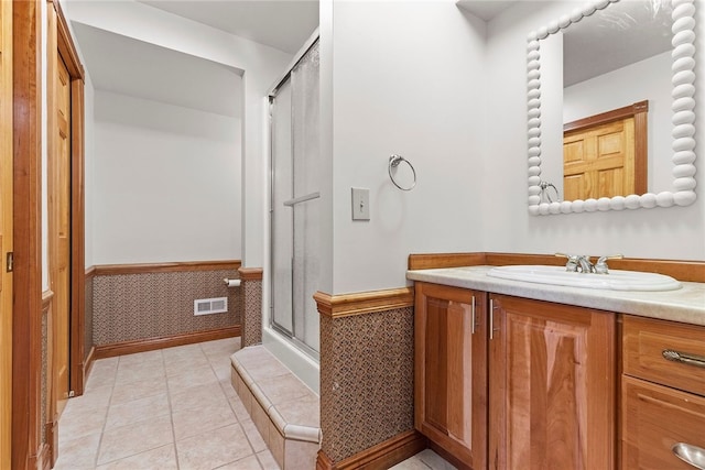 bathroom featuring tile patterned floors, a shower with shower door, and vanity