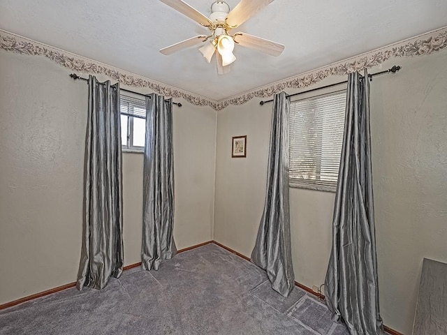 empty room featuring ceiling fan and carpet